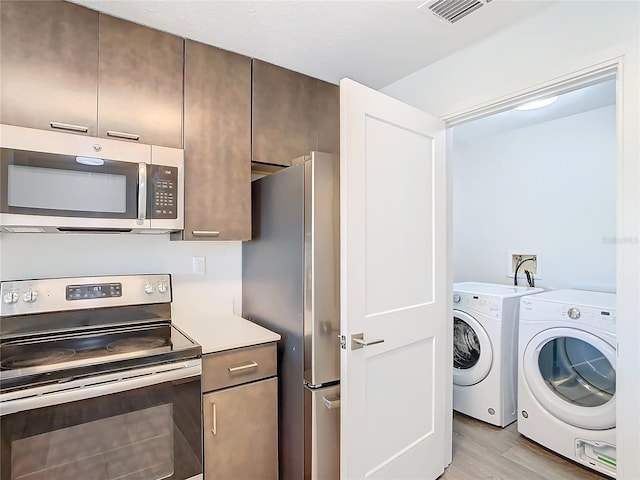 interior space with washer hookup, light hardwood / wood-style floors, and washer and dryer