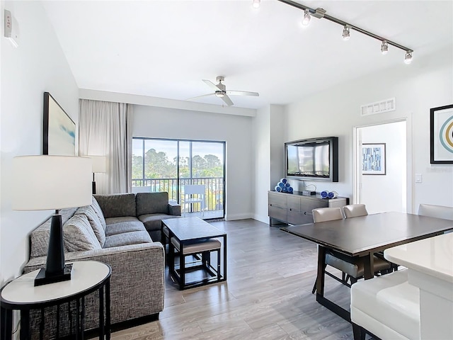 living room with ceiling fan, light wood-type flooring, and track lighting