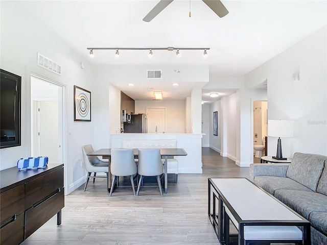 interior space with light hardwood / wood-style flooring, ceiling fan, and track lighting