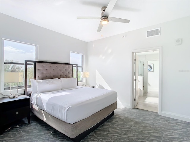 bedroom with dark colored carpet, multiple windows, and ceiling fan