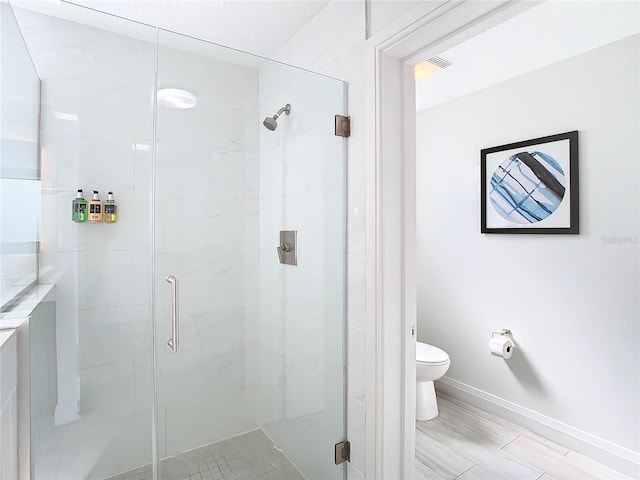 bathroom with toilet, a shower with shower door, and vanity