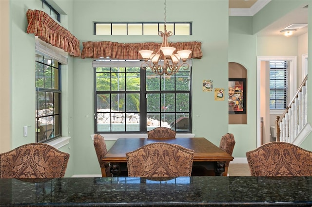 dining area with an inviting chandelier and crown molding