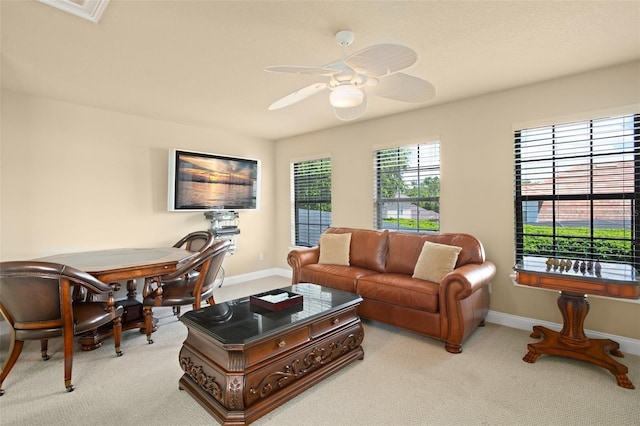 living area featuring ceiling fan, visible vents, baseboards, and light colored carpet