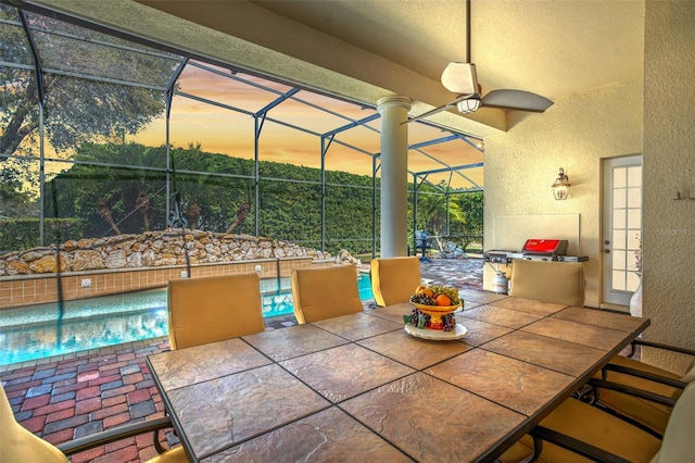 view of patio / terrace featuring outdoor dining space, a swimming pool, a lanai, and a ceiling fan