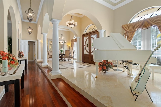 6443 Cartmel Ln, Windermere, FL 34786 - foyer entrance featuring arched walkways, a notable chandelier, crown molding, dark wood-style flooring, and ornate columns