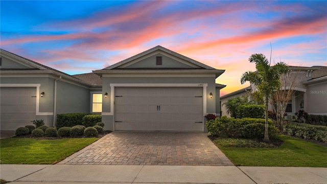 single story home with a garage and a yard