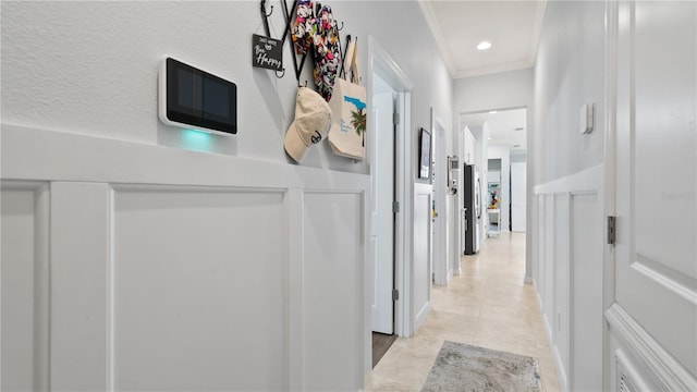 hall with ornamental molding and light tile flooring