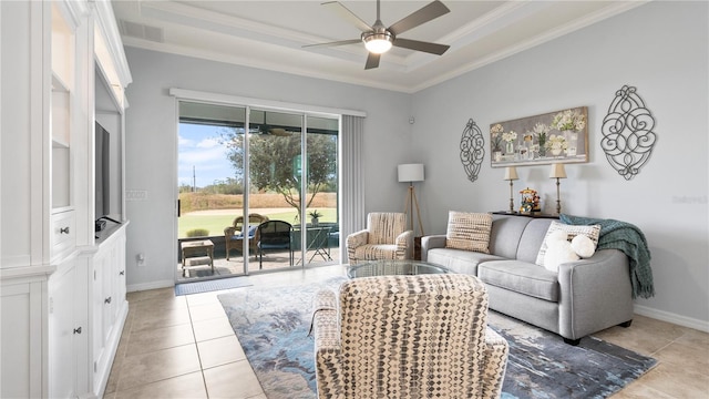 tiled living room featuring a tray ceiling, ornamental molding, and ceiling fan