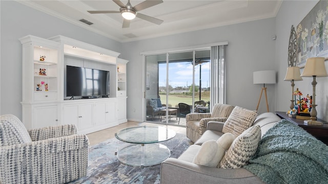 living room with a raised ceiling, ornamental molding, and ceiling fan