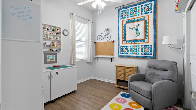 living area featuring dark wood-type flooring and ceiling fan