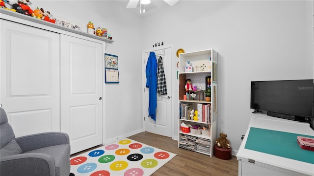 game room with ceiling fan and dark wood-type flooring