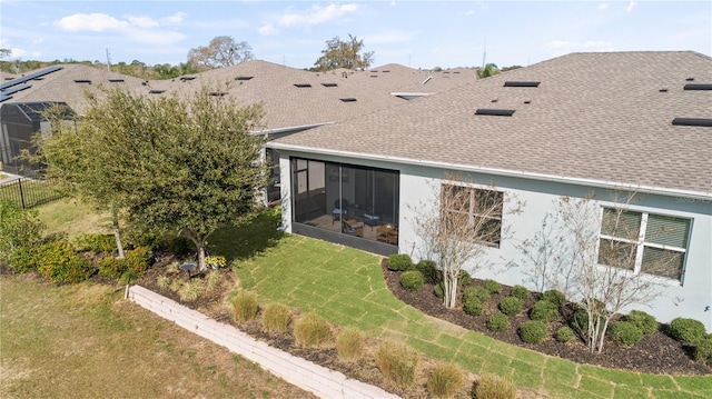 back of house featuring a yard and a sunroom