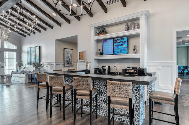 bar featuring beam ceiling, dark wood-type flooring, high vaulted ceiling, and an inviting chandelier