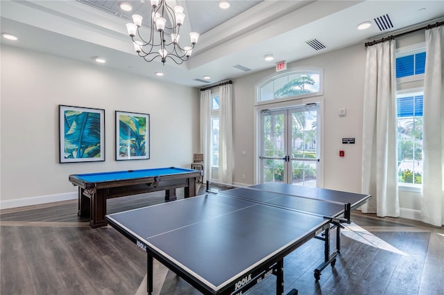 recreation room featuring pool table, dark wood-type flooring, a chandelier, a raised ceiling, and french doors