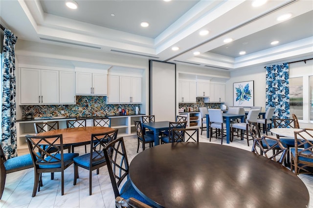 tiled dining area with a tray ceiling