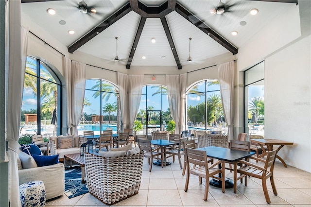 sunroom with a water view, vaulted ceiling with beams, and ceiling fan