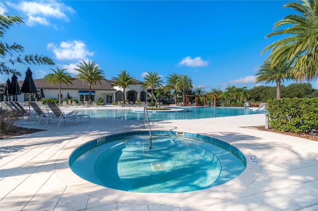 view of swimming pool with a community hot tub and a patio area