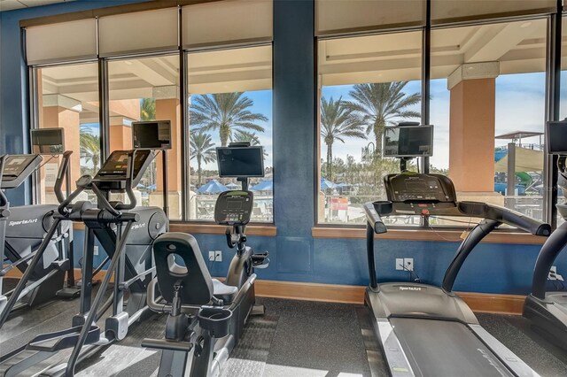 workout area featuring dark colored carpet and a wealth of natural light