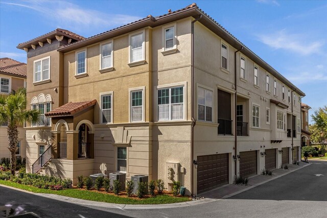 view of property with central AC unit and a garage