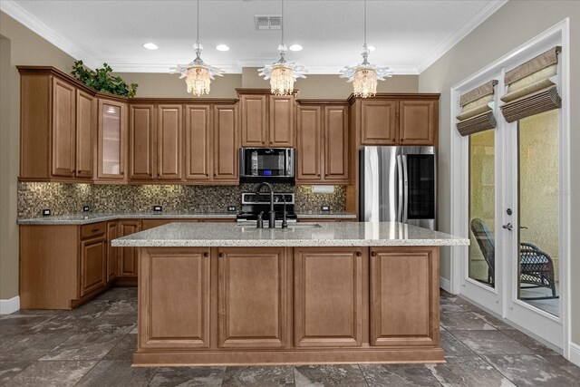 kitchen featuring a chandelier, a center island with sink, tasteful backsplash, and stainless steel appliances