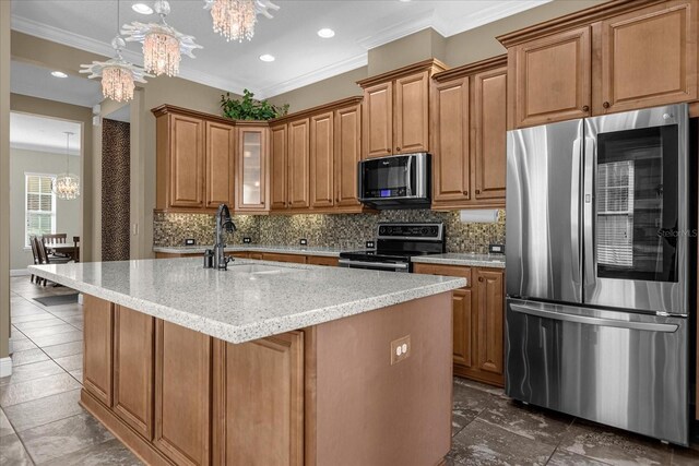 kitchen with a notable chandelier, pendant lighting, an island with sink, and stainless steel appliances