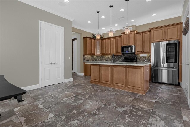 kitchen with dark tile flooring, appliances with stainless steel finishes, backsplash, a center island with sink, and decorative light fixtures