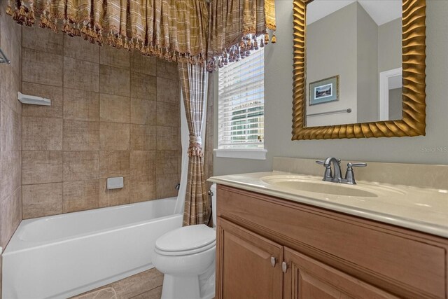 full bathroom with shower / bath combination with curtain, tile floors, vanity with extensive cabinet space, and toilet