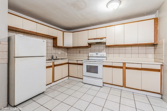 kitchen with white appliances, tasteful backsplash, white cabinetry, and sink