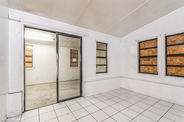 tiled empty room with lofted ceiling