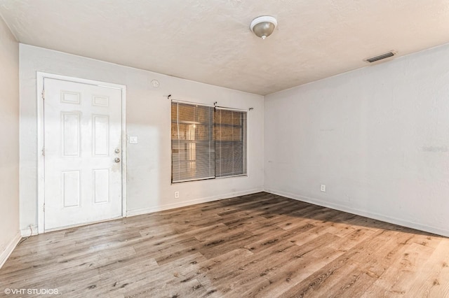 unfurnished room with hardwood / wood-style flooring