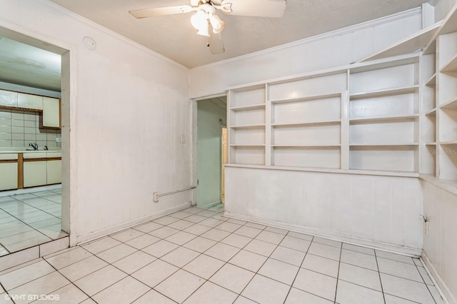 unfurnished room featuring ceiling fan, built in features, and crown molding