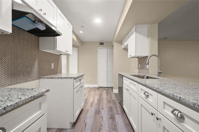 kitchen with white cabinets, decorative backsplash, sink, and wood-type flooring