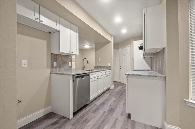 kitchen featuring backsplash, dishwasher, light hardwood / wood-style floors, sink, and white cabinets