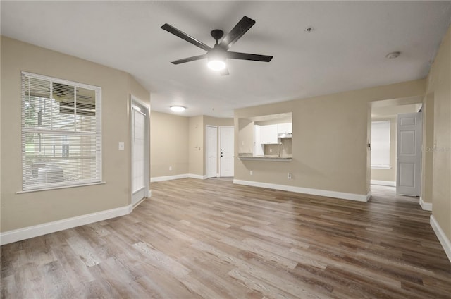 unfurnished living room featuring ceiling fan and light wood-type flooring