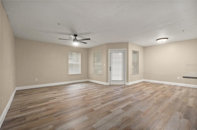 empty room with ceiling fan and hardwood / wood-style floors