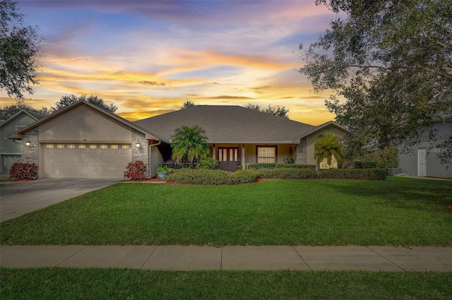 single story home with a garage and a yard