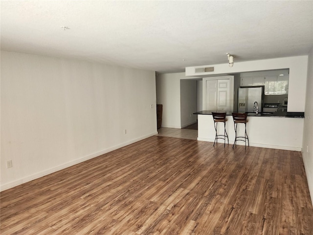 unfurnished room featuring hardwood / wood-style floors and sink