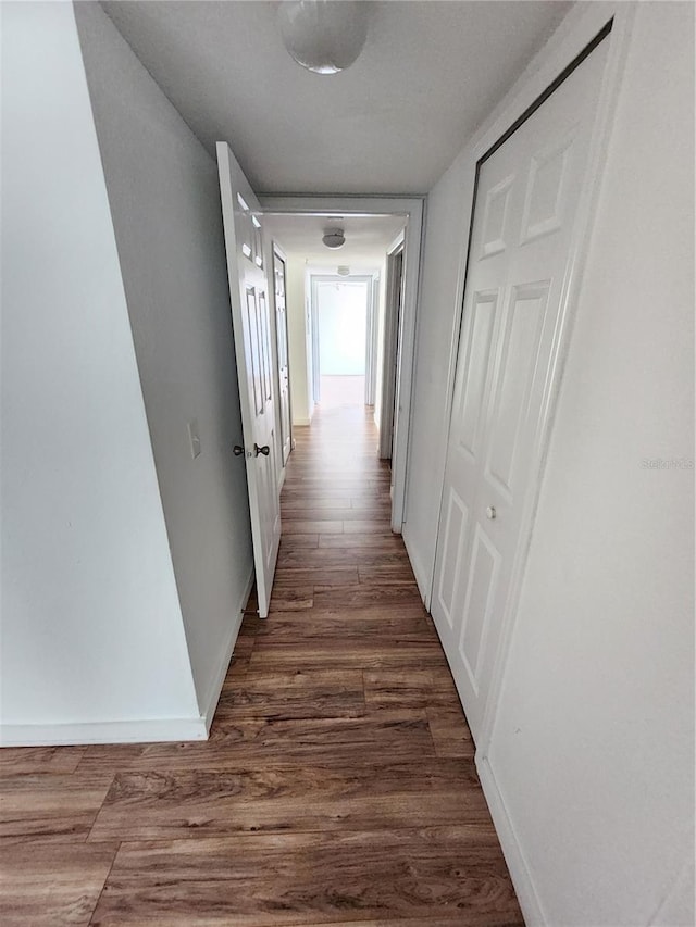 corridor with dark hardwood / wood-style flooring