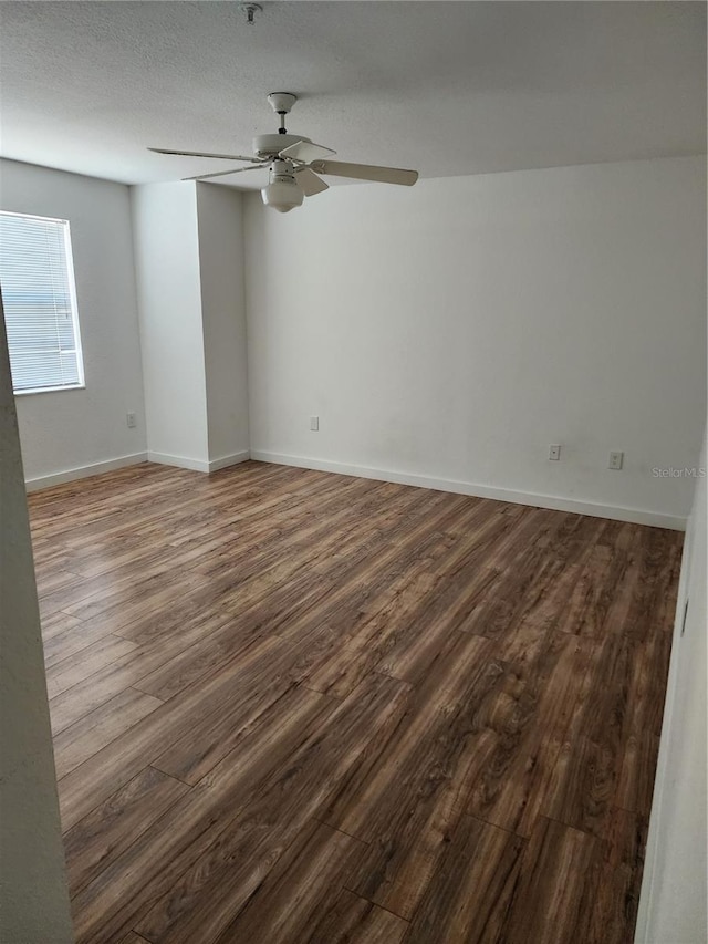 unfurnished room featuring dark hardwood / wood-style flooring, a textured ceiling, and ceiling fan