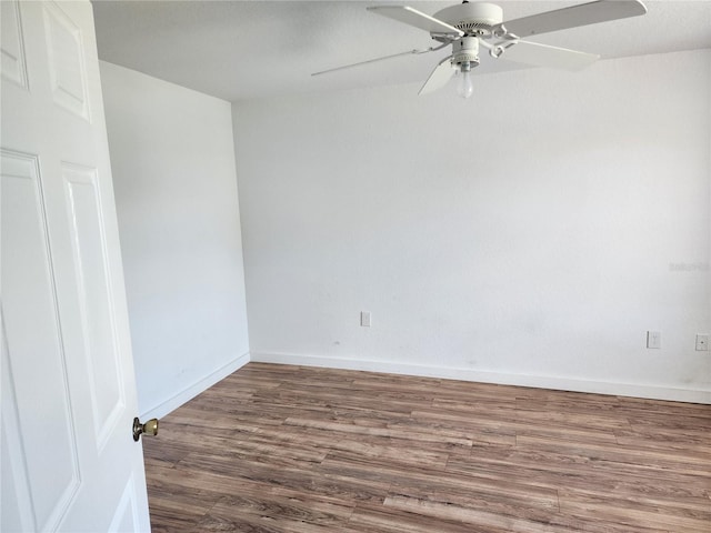 spare room with dark hardwood / wood-style flooring and ceiling fan