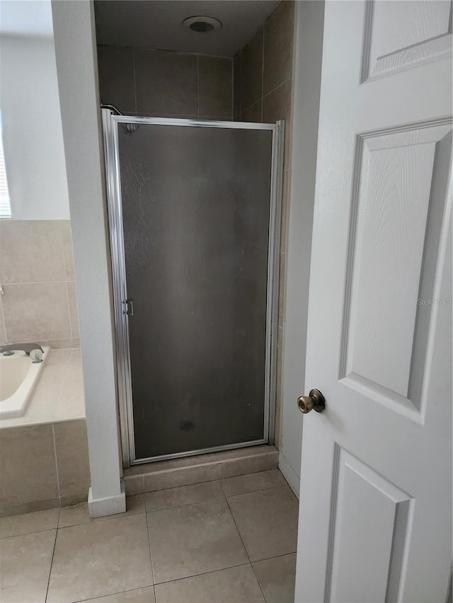 bathroom with shower with separate bathtub and tile floors