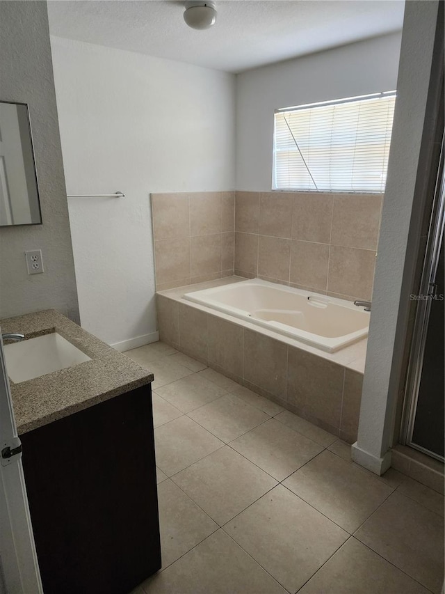 bathroom featuring tiled tub, vanity, and tile flooring