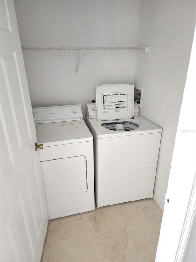 washroom with washing machine and clothes dryer, washer hookup, and light tile flooring