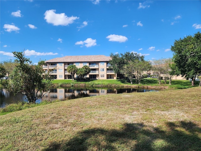 surrounding community with a lawn and a water view