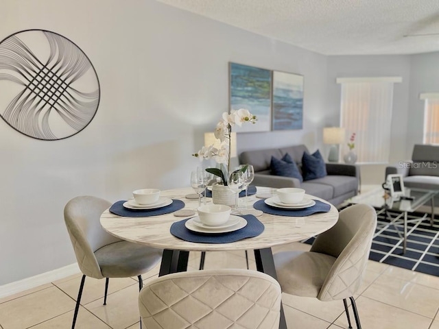 dining space featuring light tile floors and a textured ceiling