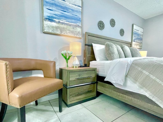 bedroom with a textured ceiling and light tile floors