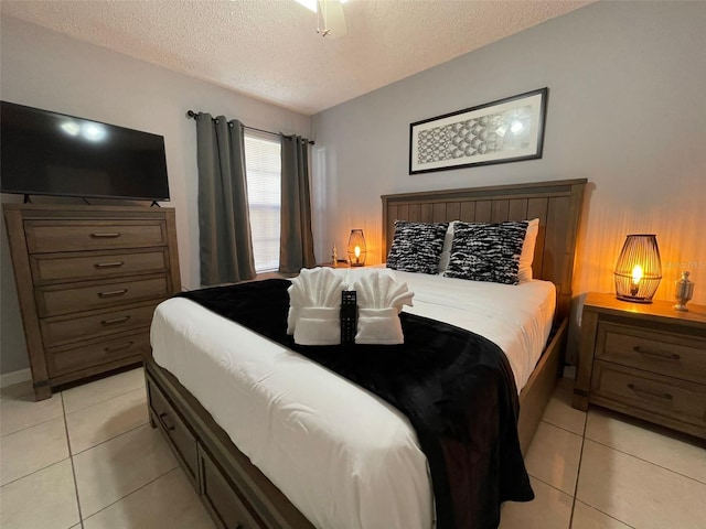 tiled bedroom with ceiling fan and a textured ceiling