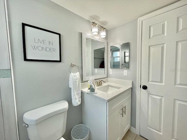 bathroom featuring tile flooring, large vanity, and toilet