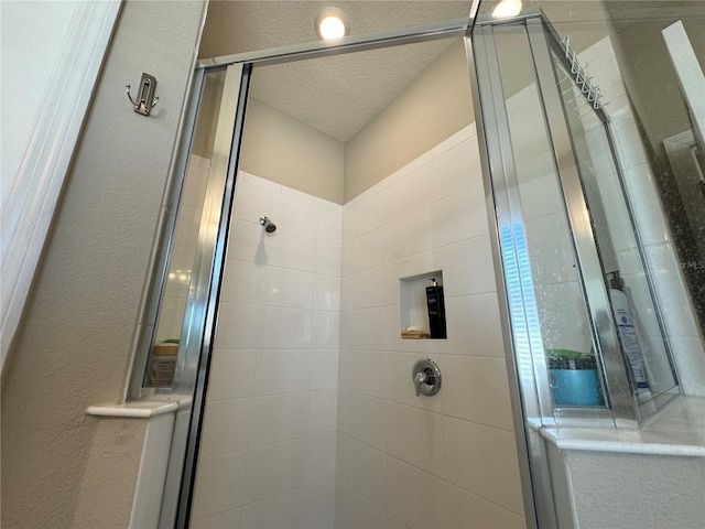 bathroom featuring a shower with door and a textured ceiling