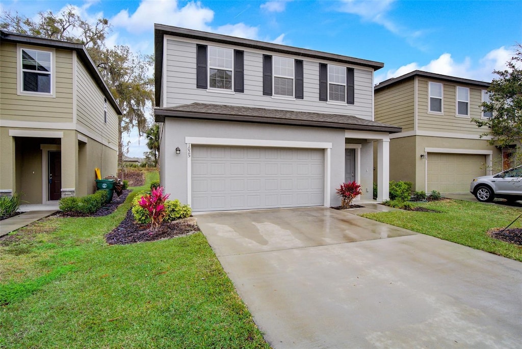 front of property with a front yard and a garage